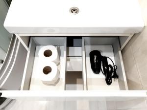 a white cabinet with a number and shoes in it at Ezerkrasts Daugavas 7 in Liepāja