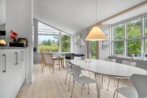 a kitchen and dining room with a white table and chairs at 1077-Thisted-Johns-Vej-33 in Klitmøller