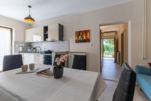 a kitchen and dining room with a table with flowers on it at Green Oasis with Terrace in Pazin