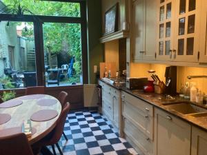 a kitchen with a table and a table and a window at Room in a garden Late CHECKOUT in Ghent
