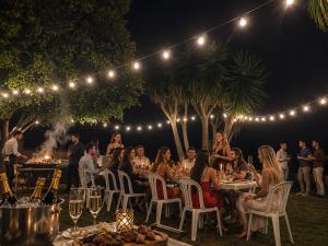 a group of people sitting at tables at a party at night at Fort Tenerife Gran Casa de Campo in Tacoronte +70 photos