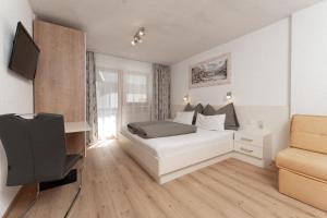 a bedroom with a bed and a desk and a chair at Appartement Gehörde-Sölden inklusive Summercard in Sölden