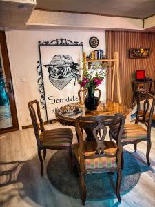 a dining room with a table and chairs with flowers on it at Smith's house in Borgo San Dalmazzo +7 photos