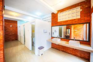 a bathroom with two sinks and a brick wall at Ndalem Prabu in Sarangan +65 photos