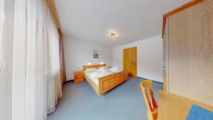 a bedroom with a bed and a table and a window at Appartement Belmonte in Sölden
