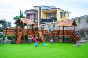 a child playing in a playground with a slide at Ndalem Prabu in Sarangan