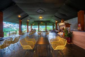 a restaurant with chairs and tables in a room at Ndalem Prabu in Sarangan
