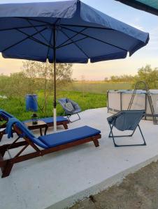 two chairs and an umbrella on a patio at Tiny Loft House in Halkidiki in Nea Potidaea