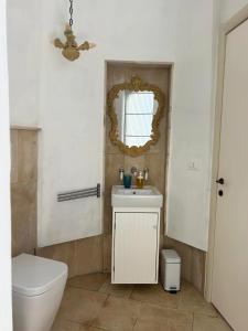 a bathroom with a toilet and a sink and a mirror at Masseria Pelosella B&B in Fasano