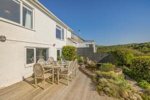 a wooden patio with a table and chairs at 4 Bed in Tintagel oc-trev in Treknow