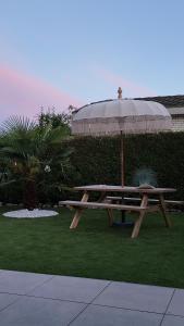 a picnic table with an umbrella on the grass at ViVe in Putten