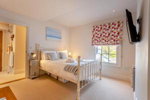 a bedroom with a bed and a television and a window at 1 Bed in Southwold oc-bate in Southwold