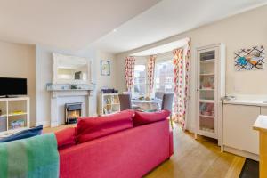 a living room with a red couch and a fireplace at 1 Bed in Southwold oc-bate in Southwold