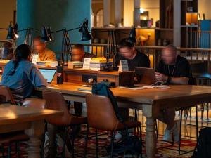 a group of people sitting at a table with a laptop at 25hours Hotel Dubai One Central in Dubai +203 photos