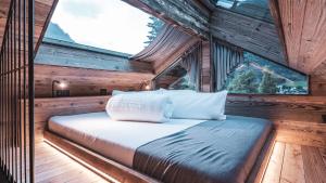 a bed in the middle of a room with a window at BergNest in Huben