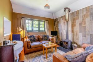 a living room with brown leather furniture and a fireplace at 2 Bed in Minehead oc-77362 in Withypool