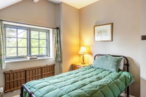 a bedroom with a bed and a window at 2 Bed in Minehead oc-77362 in Withypool
