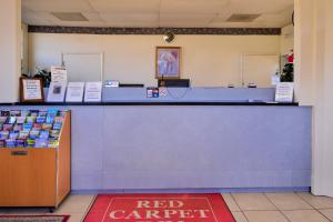 una alfombra roja delante de un mostrador rojo en una tienda en Red Carpet Inn Battleboro, en Battleboro