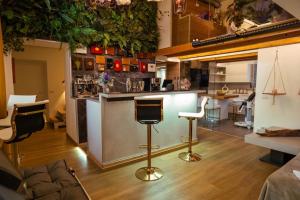 a kitchen with a bar with plants on the wall at Haven Loft Como - Private Spa, Parking & Jacuzzi in Como