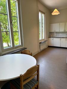 an empty room with a white table and windows at Apartment Centrum Karlshamn in Karlshamn