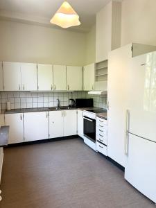 an empty kitchen with white cabinets and a refrigerator at Apartment Centrum Karlshamn in Karlshamn