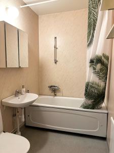 a bathroom with a sink and a bath tub and a toilet at Apartment Centrum Karlshamn in Karlshamn