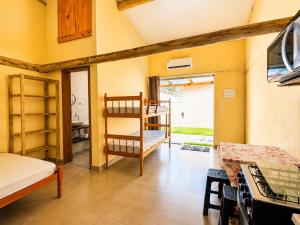 a room with a bunk bed and a kitchen at Chalés & Suítes Praia Barequeçaba I Cozinha Compacta in São Sebastião
