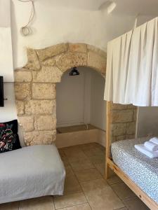 a bedroom with a bed and a stone wall at Masseria Pelosella B&B in Fasano