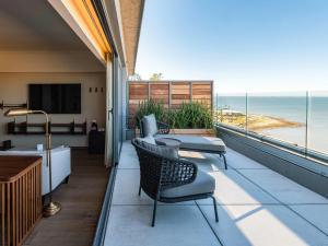 a balcony with chairs and a view of the ocean at Costanero Hotel Montevideo - MGallery Collection in Montevideo