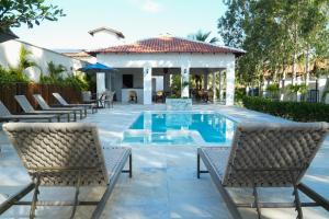 a swimming pool with chairs and a gazebo at Pousada Vila Pequi in Barreirinhas