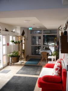 a living room with a red couch and a table at Hotel-Gasthof-Destille-Eisenbahn in Mosbach