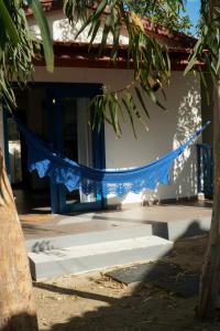 a blue net in front of a building with a cat at Pousada Vila Pequi in Barreirinhas