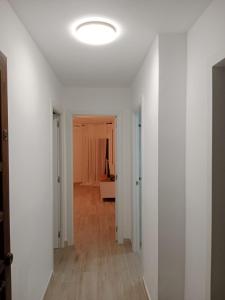 an empty hallway with a white wall and a ceiling at Formentor Inn in Salou +1 photo