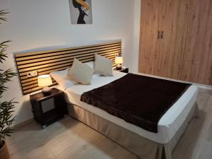 a bedroom with a large bed with two lamps at Formentor Inn in Salou