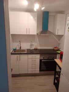 a kitchen with white cabinets and a sink at Formentor Inn in Salou