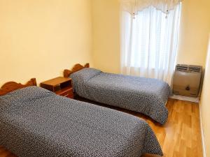 a bedroom with two beds and a window with a television at Barrio Aeropuerto depto 2 dormitorios en Río Grande in Río Grande