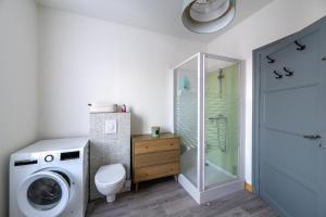 a bathroom with a washing machine and a toilet at La lande appart in Tranzault