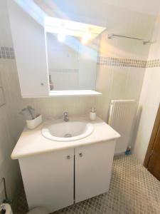 a bathroom with a white sink and a mirror at Tranquil central apartment in Ampavris +19 photos