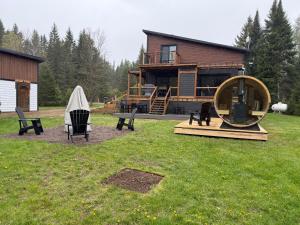ein Haus mit einem großen Spiegel und Stühlen im Garten in der Unterkunft Oasis thermal Mauricie Chalet NE Chic Shack in Saint Mathieu Du Parc