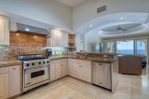 a large kitchen with a stove and a sink at Casa 4 C's in Cabo San Lucas