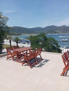 a wooden picnic table and chairs on a patio overlooking the water at Ελένη in Iraklitsa