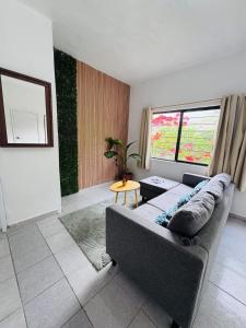 a living room with a couch and a large window at Loft Mango in Tuxtla Gutiérrez