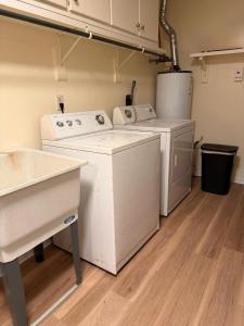 a laundry room with white washers and dryers in it at WildFlower Inn in Satsuma +4 photos