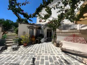 a courtyard of a house with chairs and a tree at Masseria Pelosella B&B in Fasano