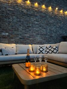 a couch with candles and wine glasses on a table at Huys van Haeghe in Zoutleeuw