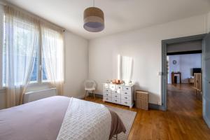 a white bedroom with a bed and a window at La lande appart in Tranzault