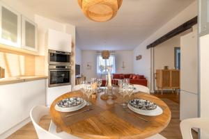 a kitchen and dining room with a wooden dining table at La lande appart in Tranzault