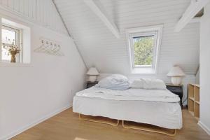 a white bedroom with a bed in a attic at 20623-Samso-Besser-Hovedgade-9 in Besser
