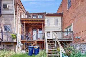a house with a staircase next to a building at Steps to Dtwn & Rock River! Couples Retreat in Janesville