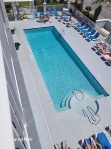 a swimming pool at a resort with lounge chairs at Grand Caribbean in Orange Beach